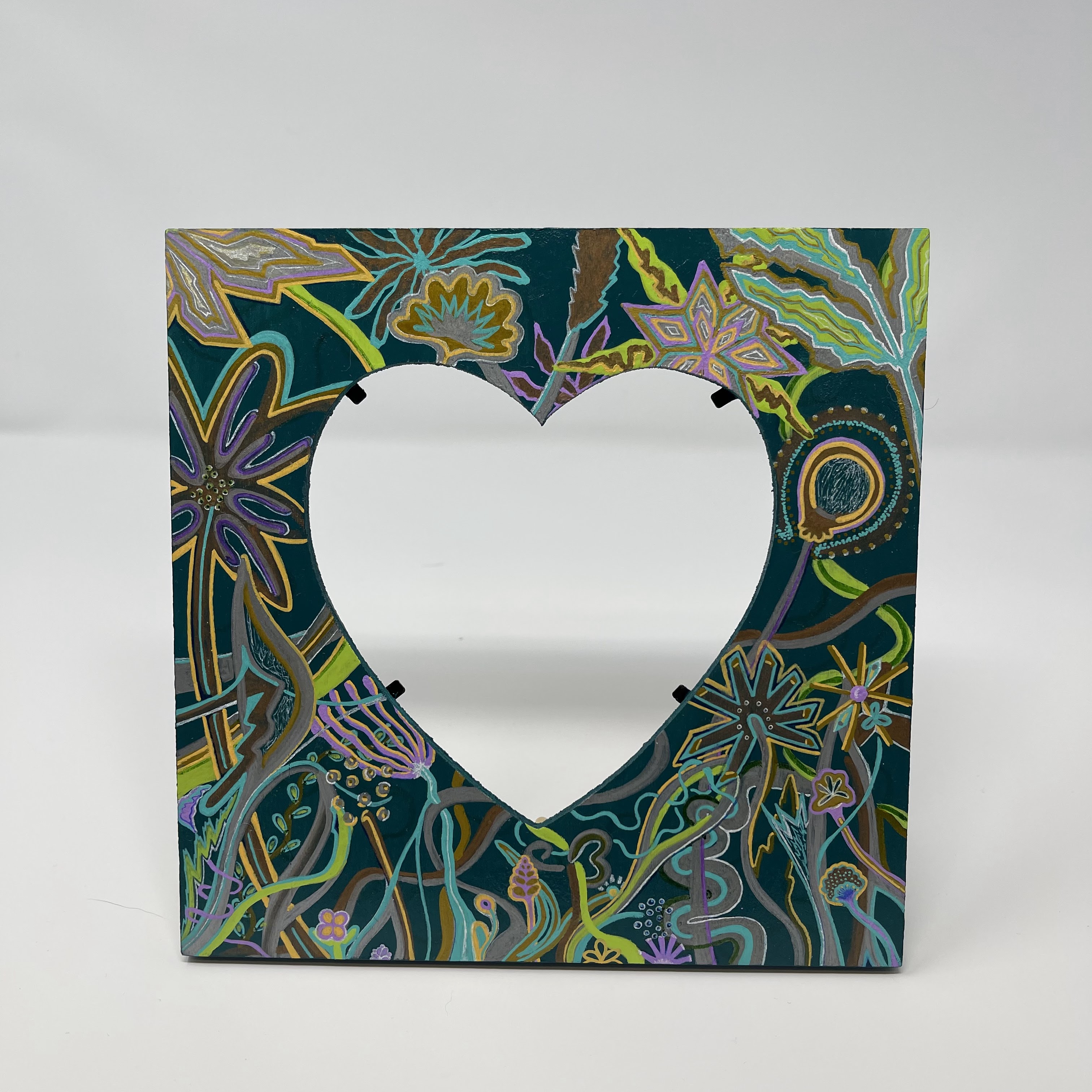 #11 Square teal picture frame with 4x5" heart-shaped cut-out. Decorated with metallic floral design. 8x8x0.25"