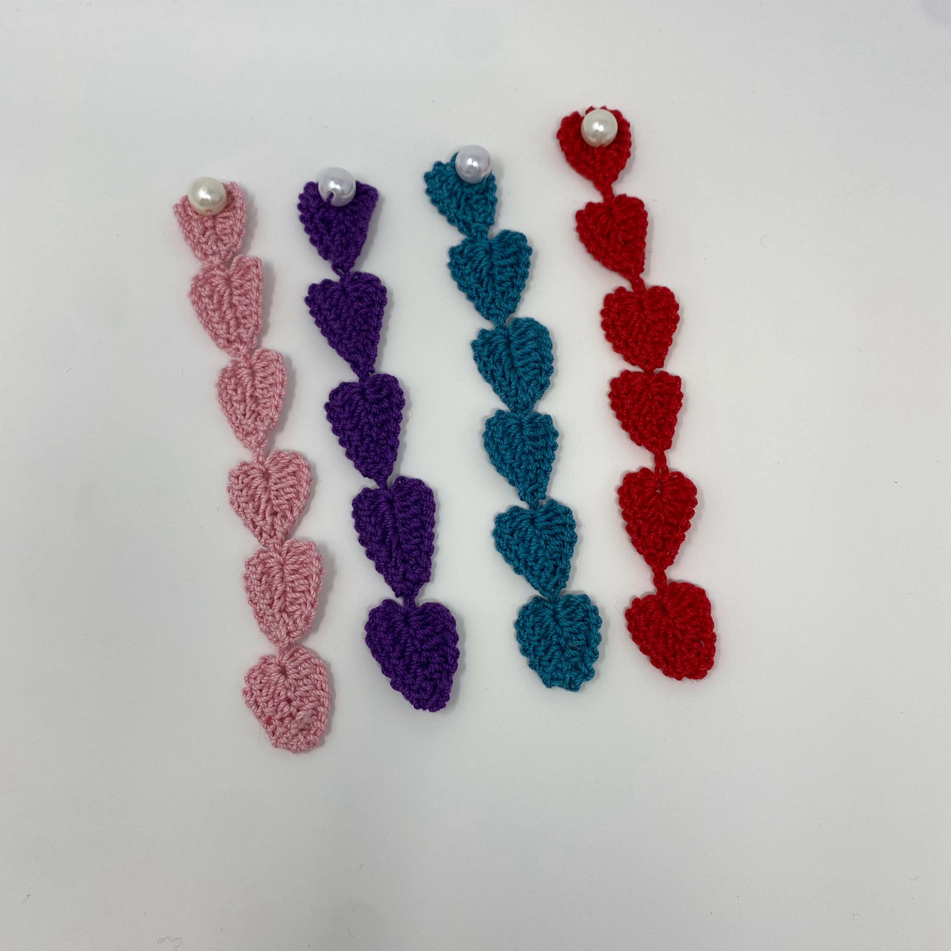 #32 Four crocheted heart chain bookmarks in pink, purple, blue, and red