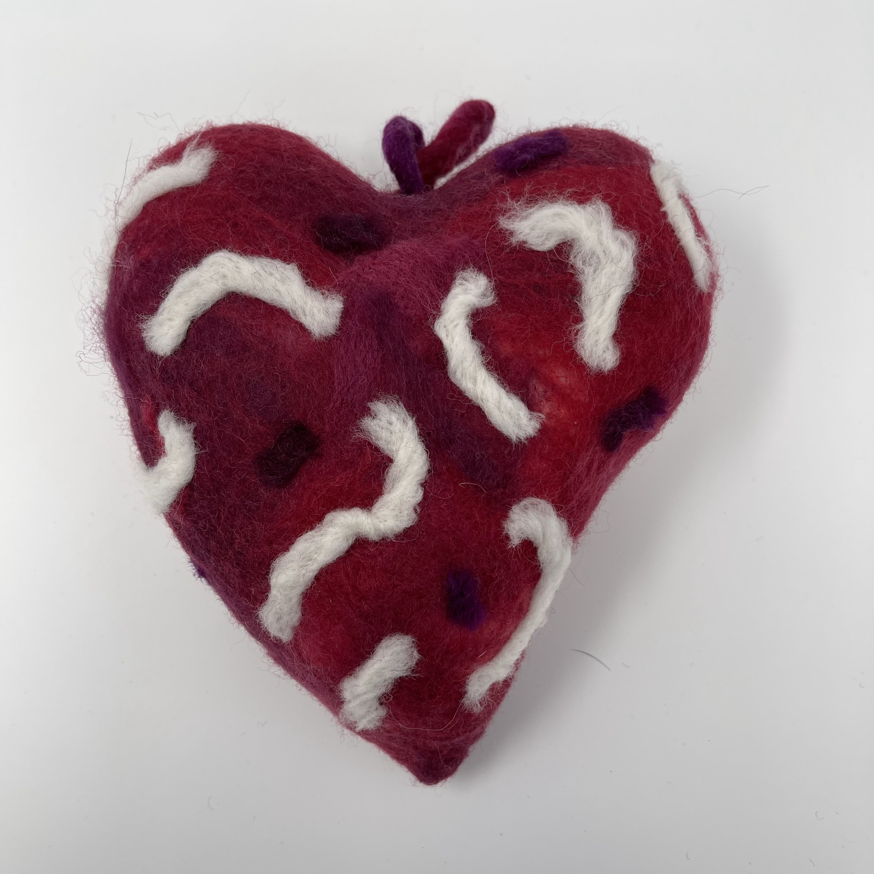 #33 Stuffed felted red heart with thick white squiggly designs. 7x7x4"