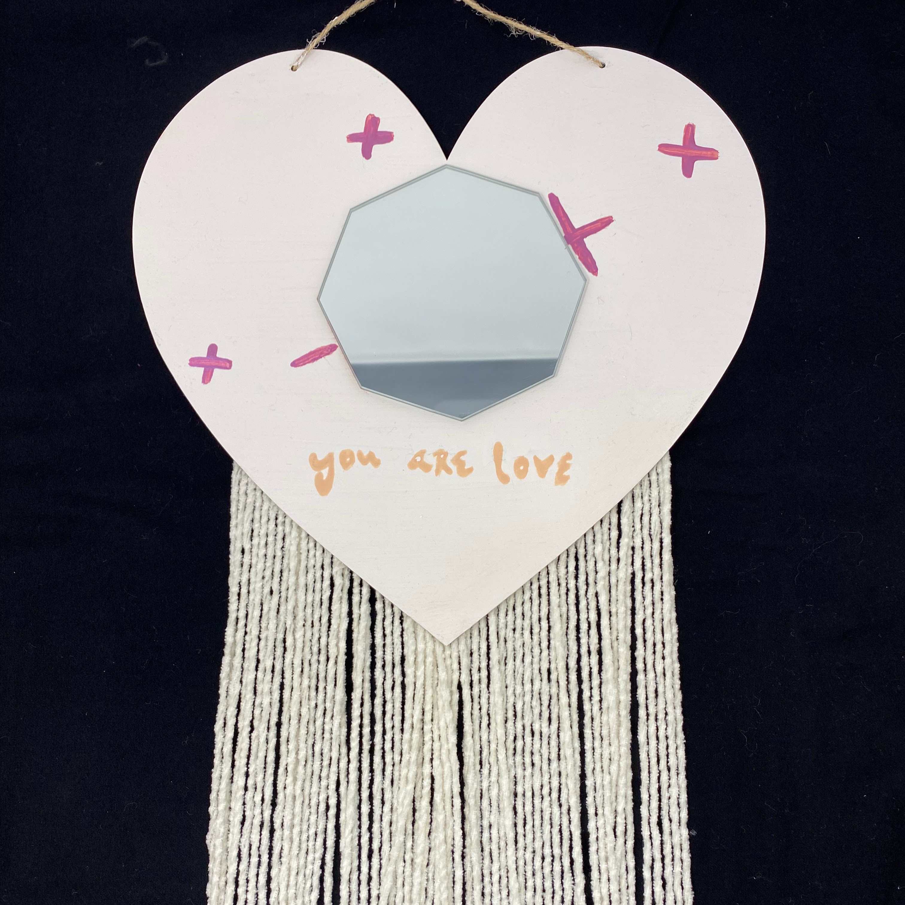 #35 White wood heart wall hanger with octagonal mirror and pink painted decorations and white fringe, with you are loved message