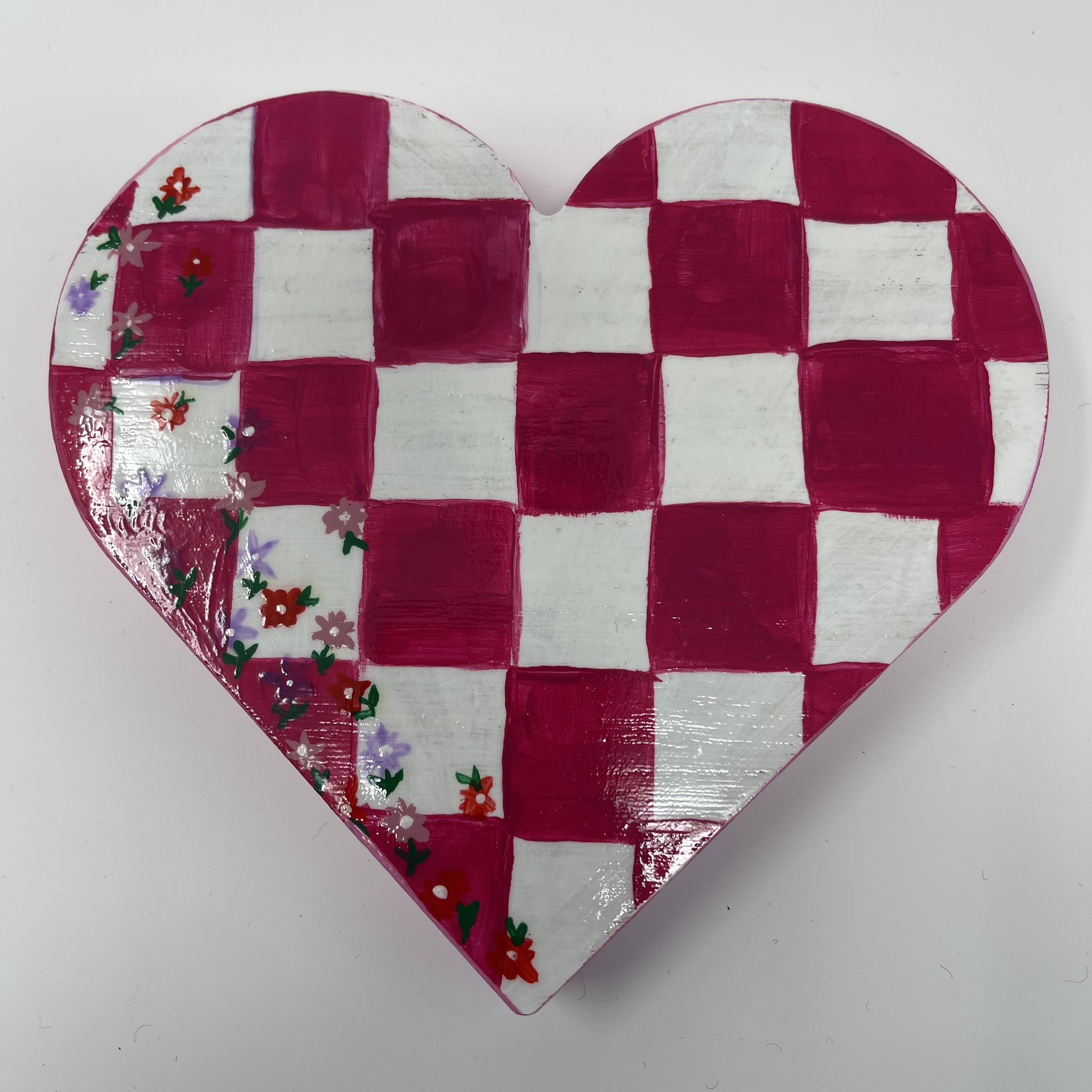 #36 Wood heart with pink and white checkerboard with flower motif on left edge. 7x7x1"