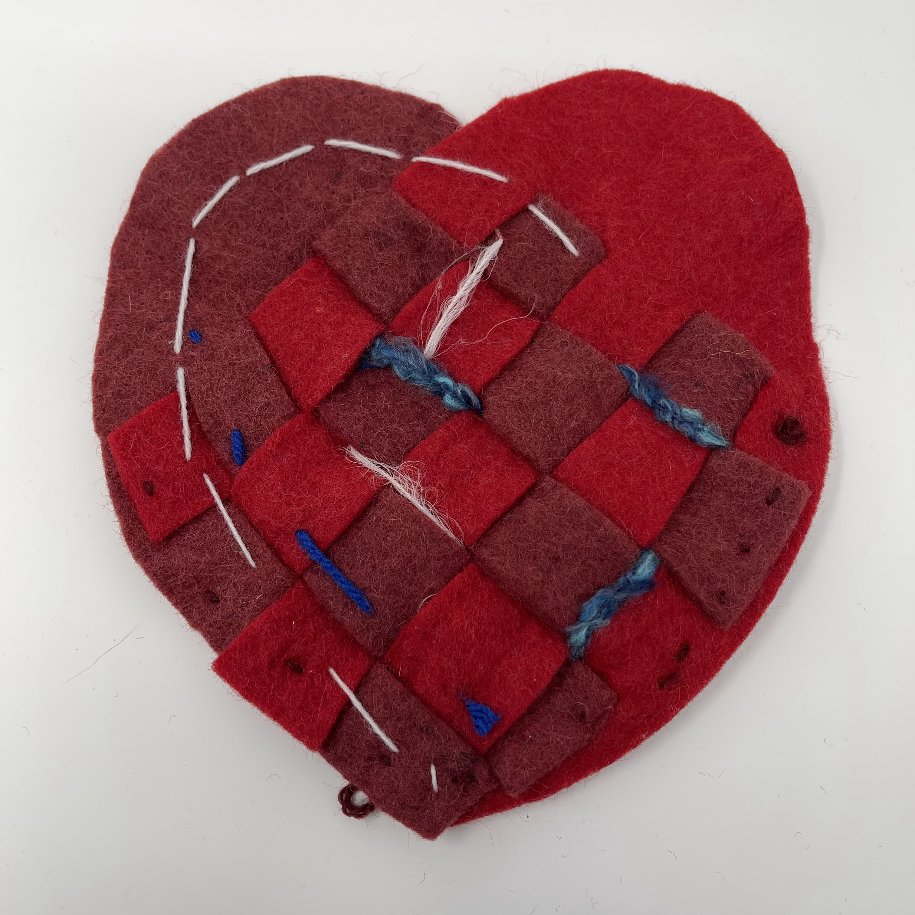 #52 Woven felted heart, shades of red with white and blue highlights. 9x9x0.25"