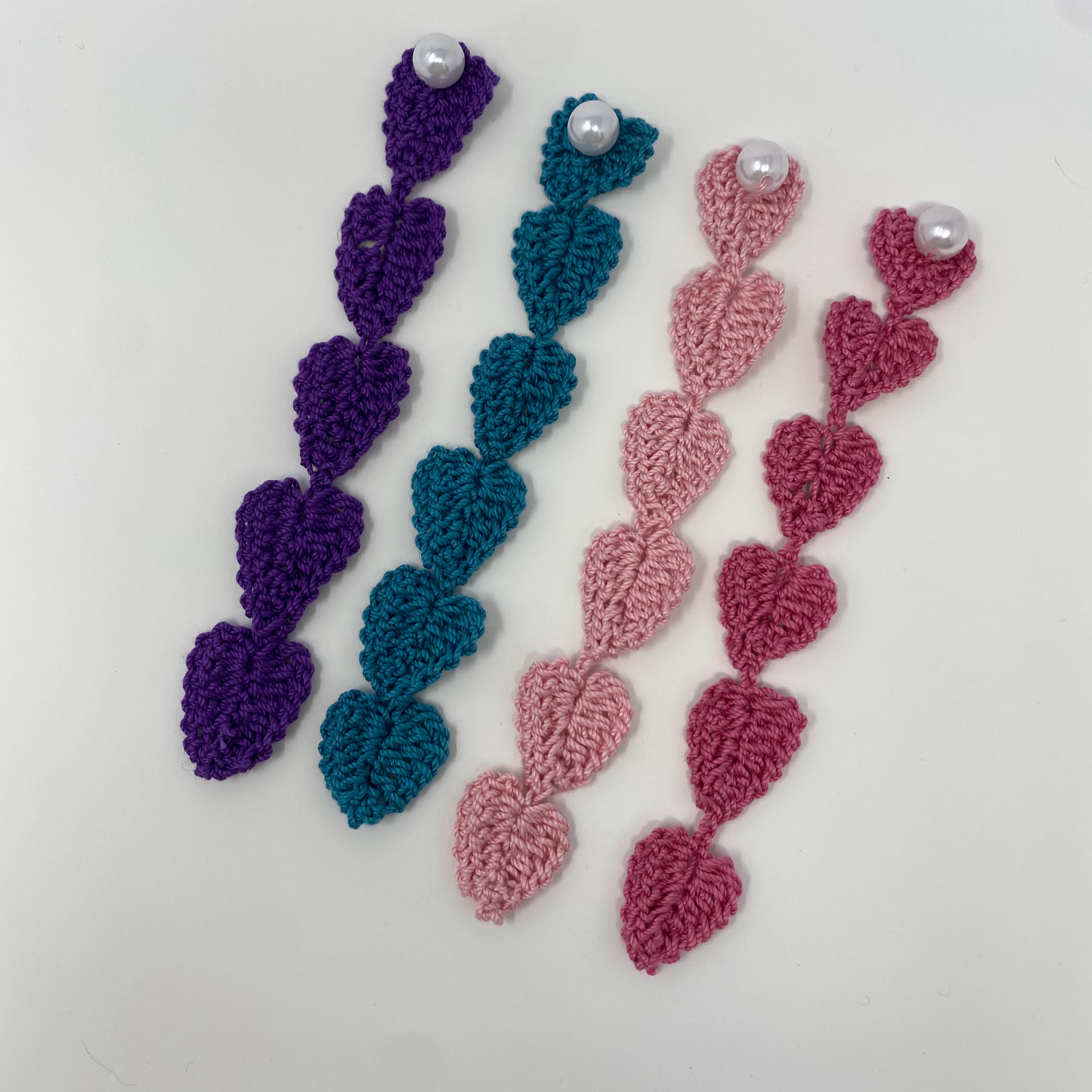 #59 Four crocheted heart chain bookmarks in pink, purple, blue, and red