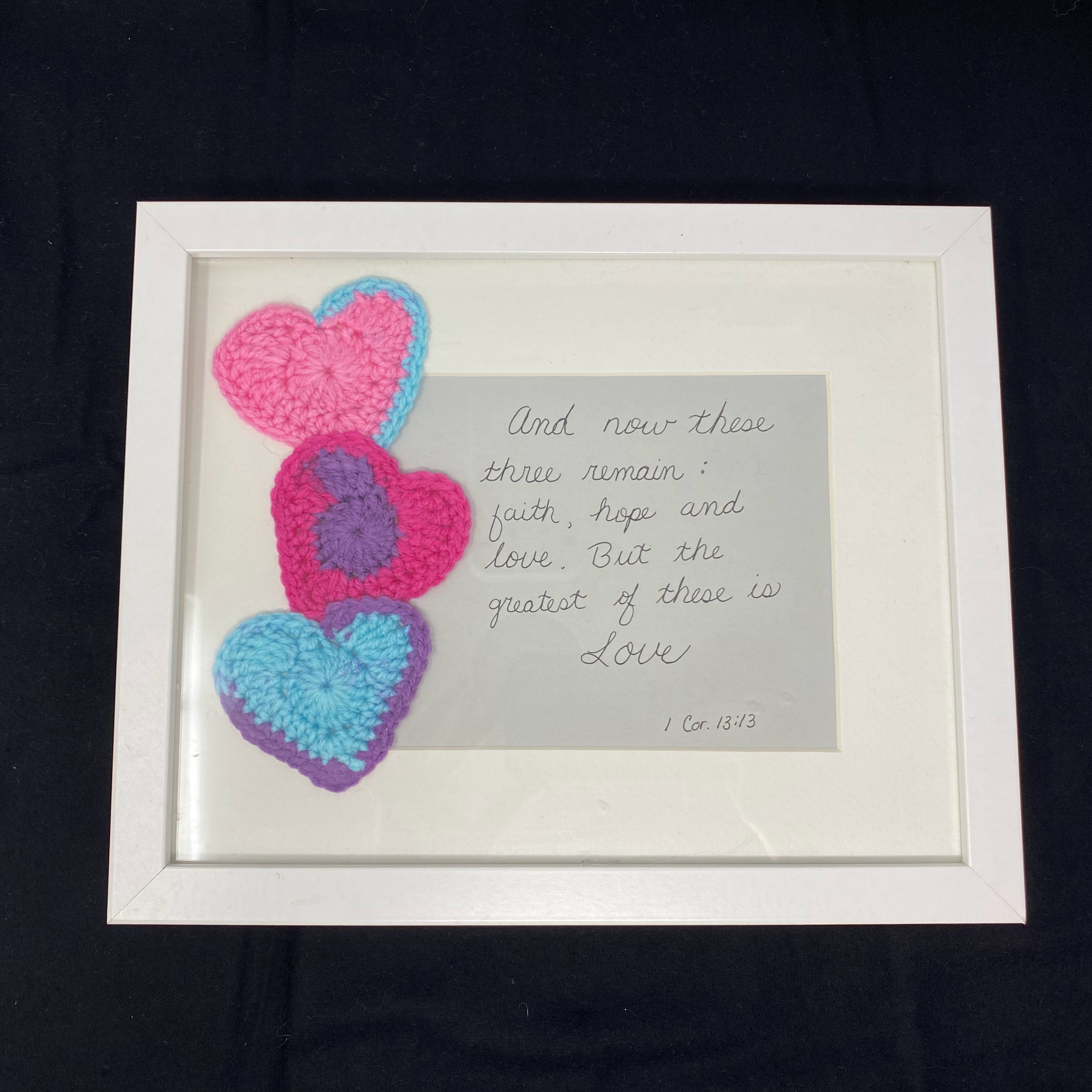 #66 White frame with three crocheted hearts in shades of pink, purple, and blue with faith, hope, and love verse